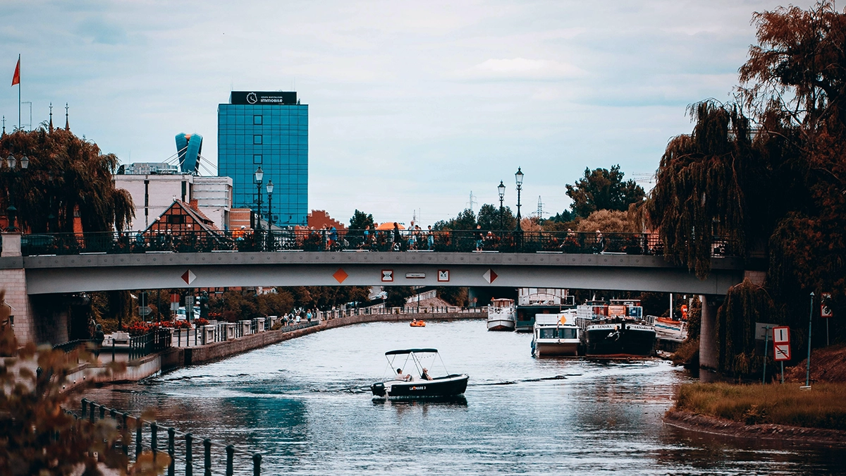 A boat passes along the Thames under Putney Bridge