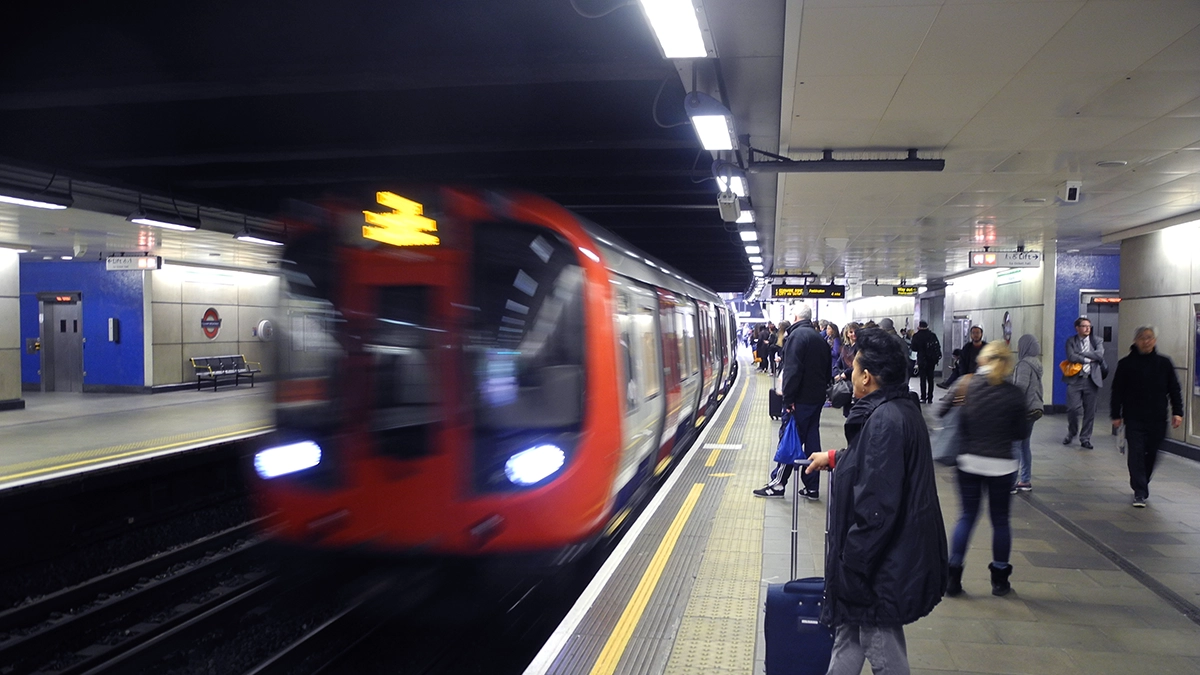 A busy platform of commuters waits for a tube train at Fulham Broadway underground station