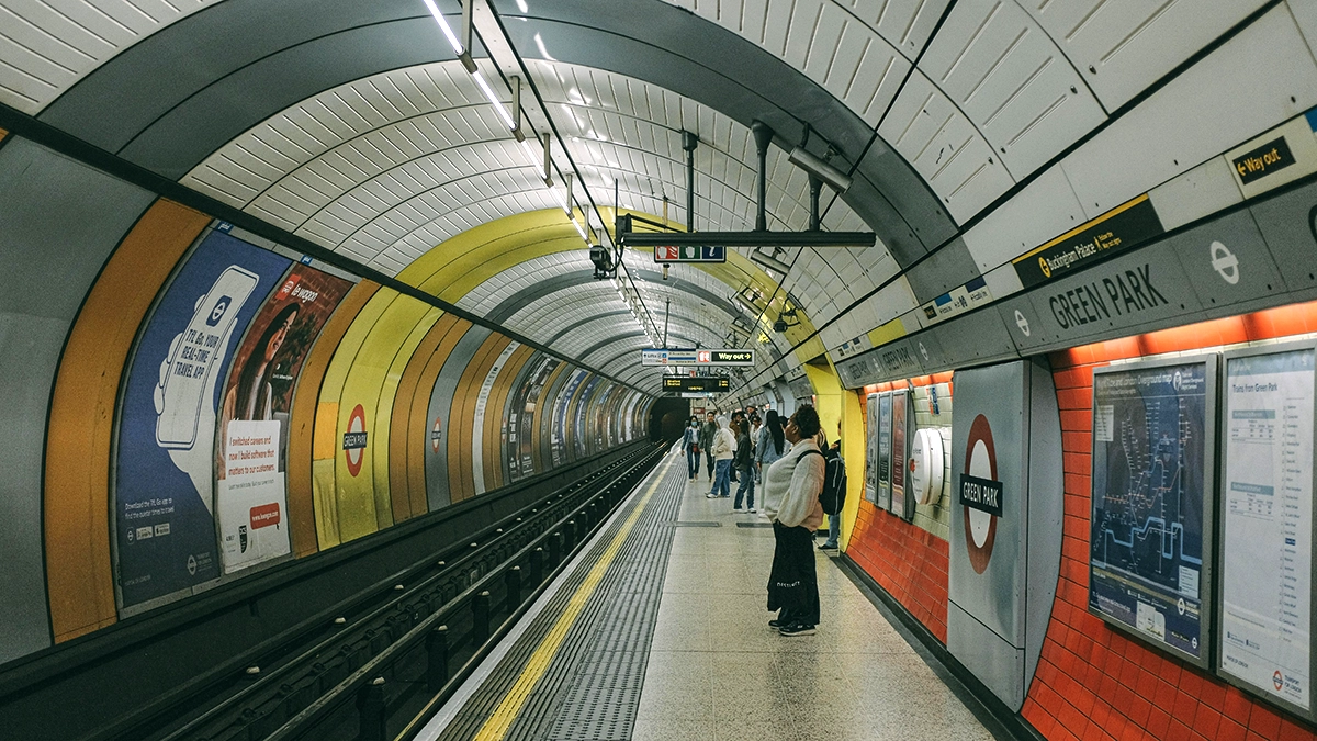Commuters on a busy platform at Green Park station look at the cross track adverts