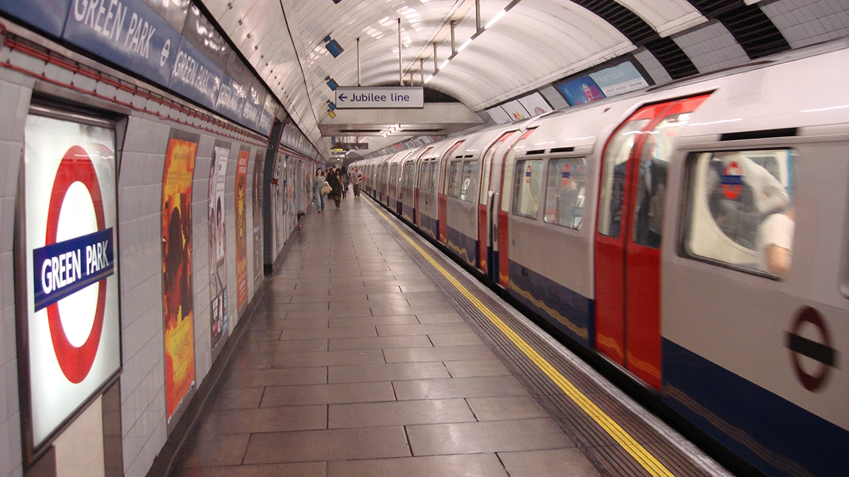 Platform adverts at Green Park underground station next to a tube train