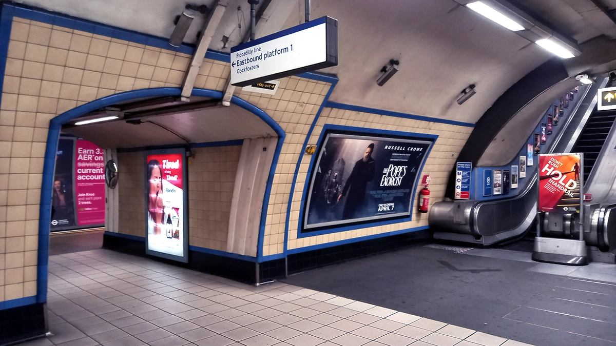 A 12 sheet poster at the bottom of an escalator at Manor House tube station