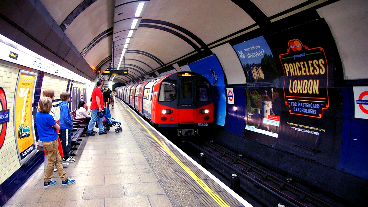 A tube train arriving in front of 16 sheet adverts at Mornington Crescent station