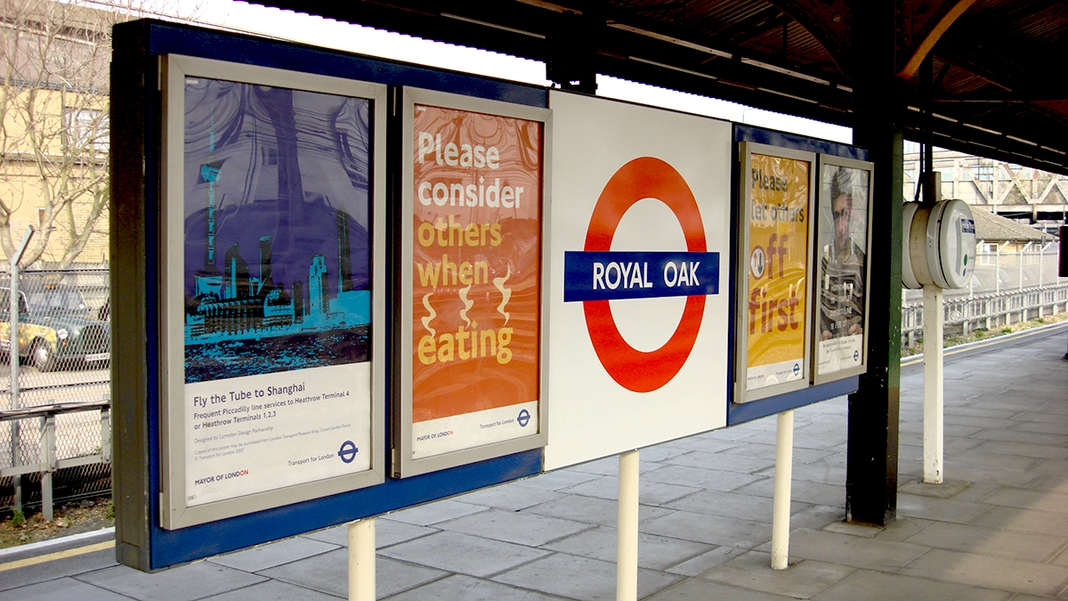 A tube roundel and 4 sheet posters at Royal Oak station