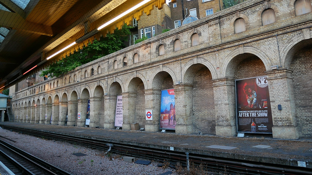 Cross track adverts between railway arches on the surface level platforms at South Kensington station