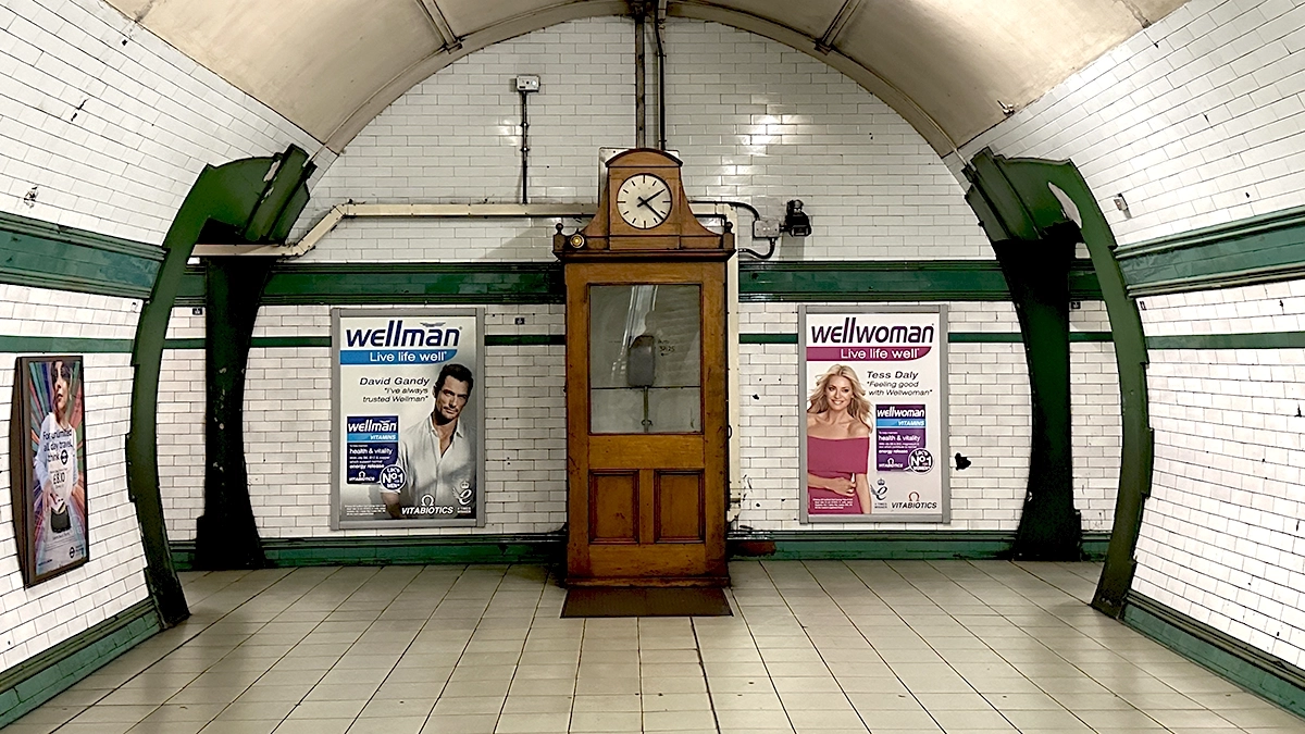 Station 12 sheet posters flank a staff information box with a clock at the top